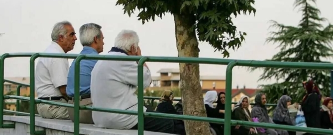 تصویر نمادین یک بازنشسته و اسکناس‌های ناچیز در کنار سبد کالای گران قیمت نوروزی